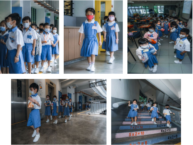 Young children in blue school uniforms and face masks walk through school hallways, a classroom, and stairs.