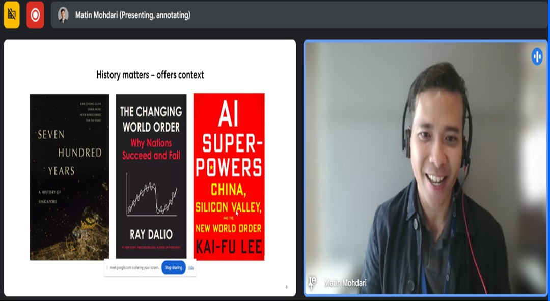 Man wearing headset smiles on video call beside a slide showing three book covers about history and AI.