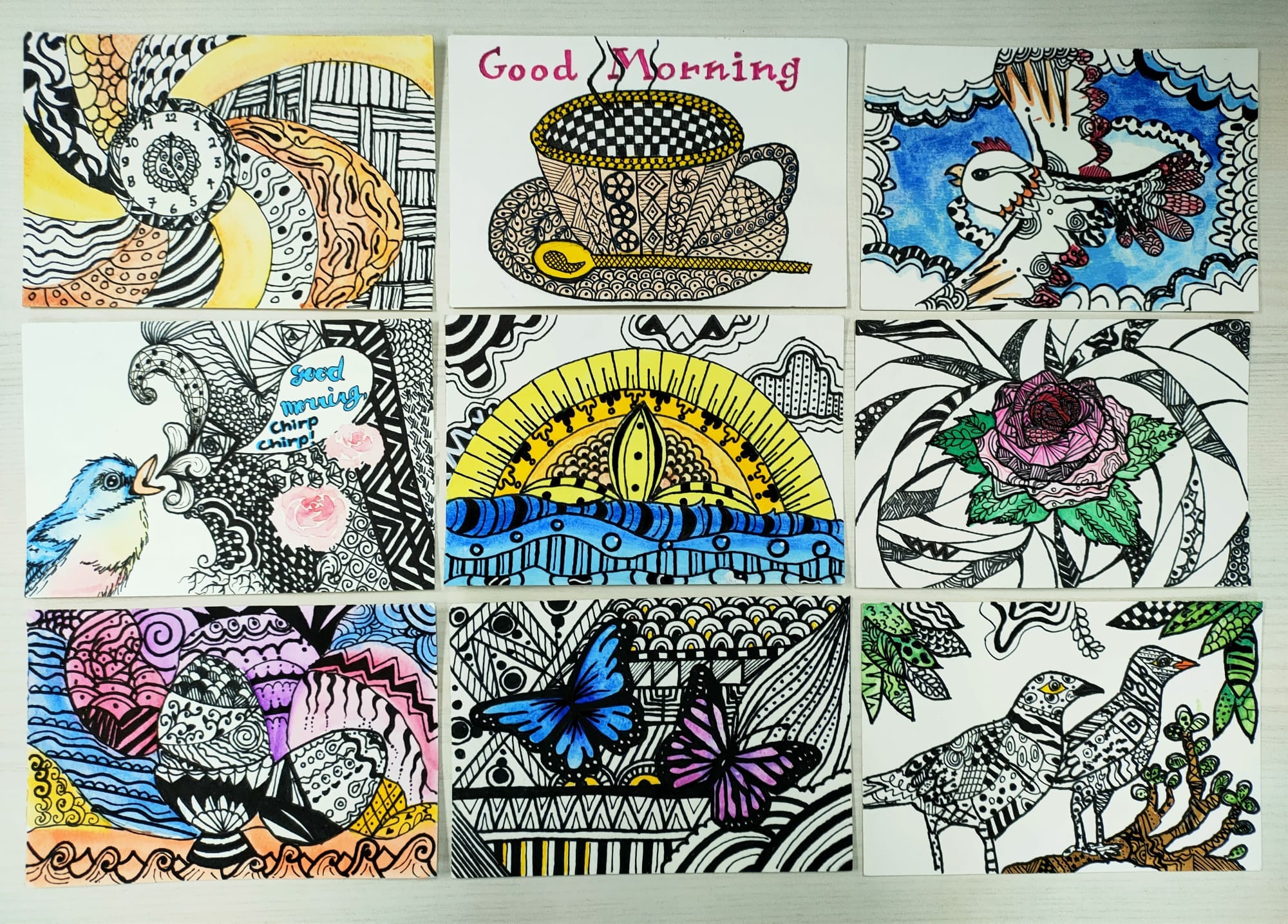 Nine hand-drawn zentangle art cards featuring birds, a teacup, butterfly, rose, and sunrise with colorful ink patterns.