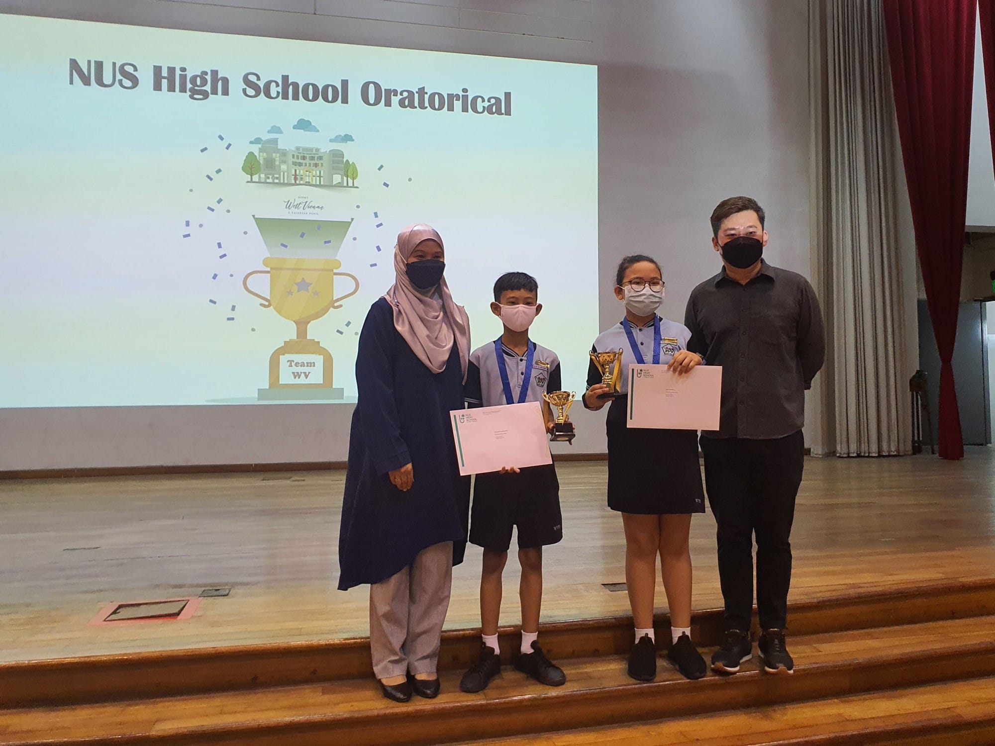 Four masked people on a stage holding trophies and certificates before an NUS High School Oratorical event slide.