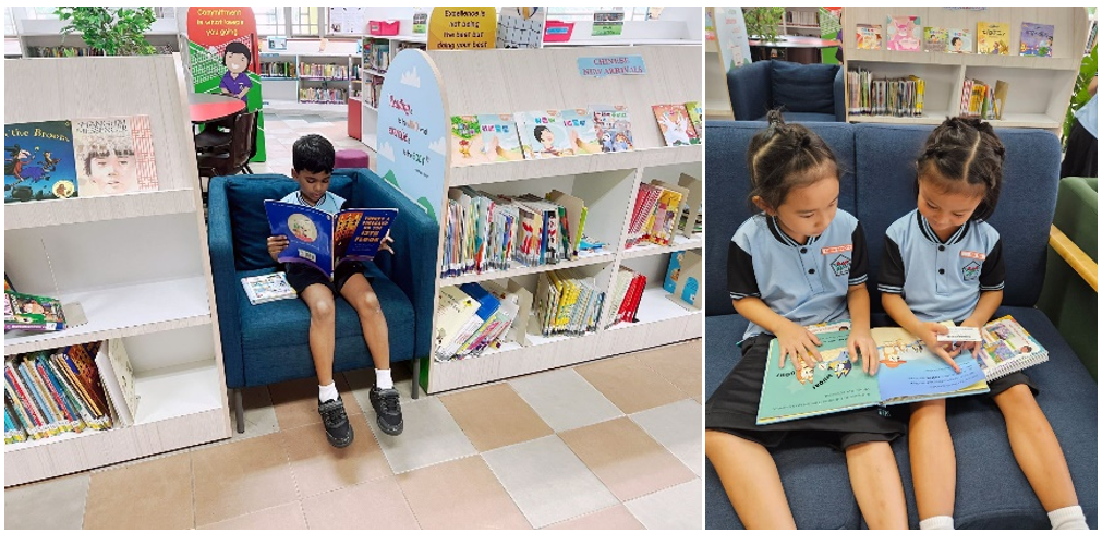 Three children in school uniforms read books on blue sofas in a colorful library with shelves of books.