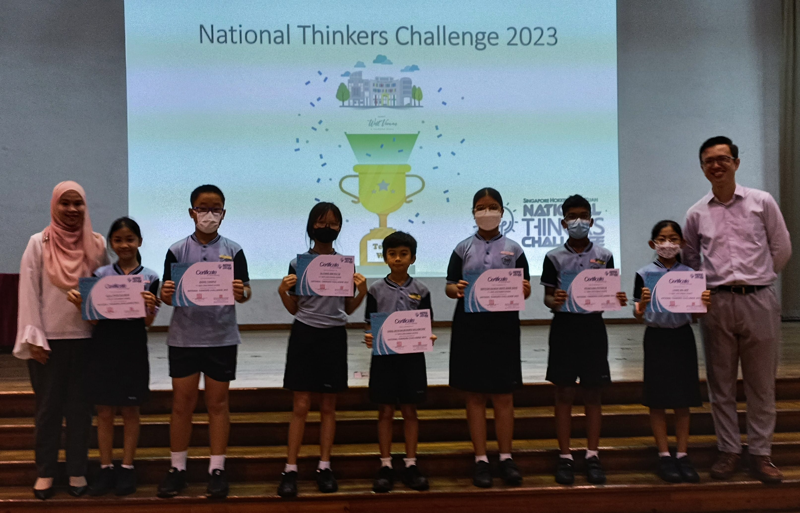 Six students hold certificates on stage at the National Thinkers Challenge 2023, flanked by two adults.