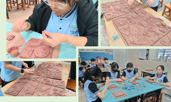 Students in blue uniforms carving designs into flat clay tiles during an art class.