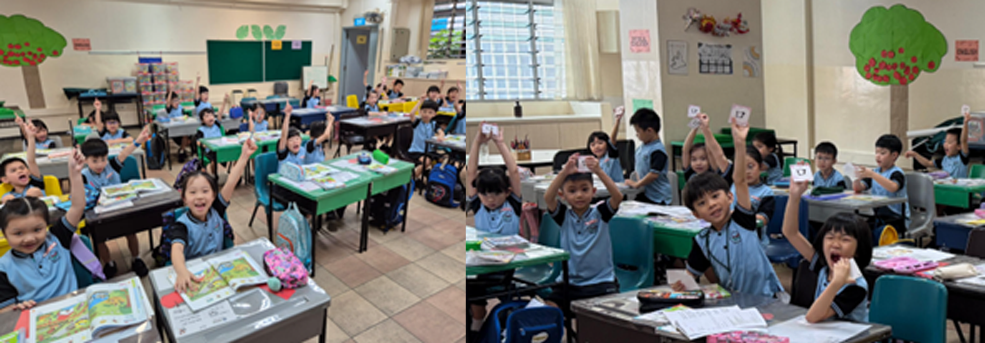 Young students in blue uniforms sit at classroom desks, raising hands and holding up small cards enthusiastically.