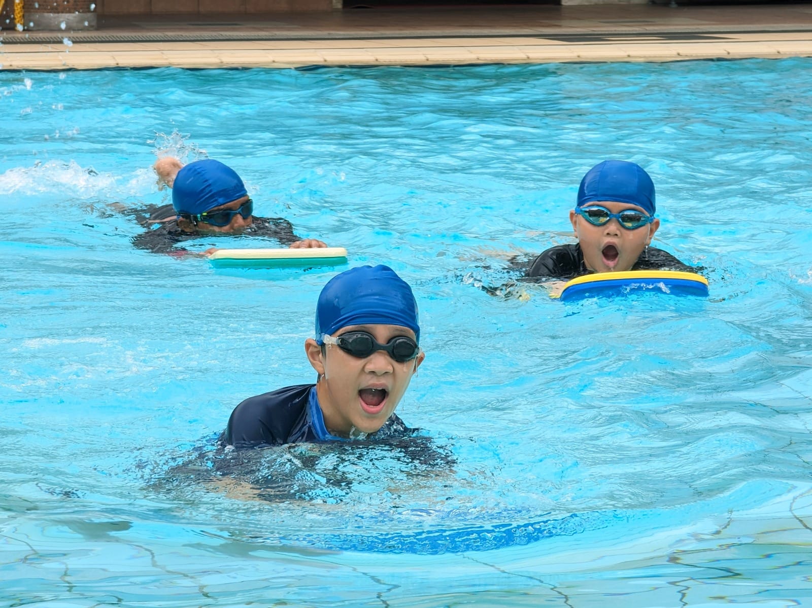 Pupils take part in a swimming lesson, learning water-safety skills and developing their swimming techniques, confidence, and physical fitness.