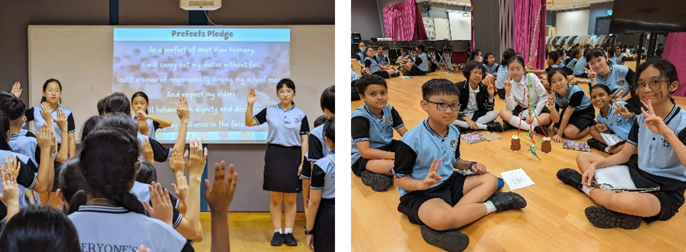 Students in blue uniforms recite a Prefects Pledge on a projected screen while others sit on a hall floor.