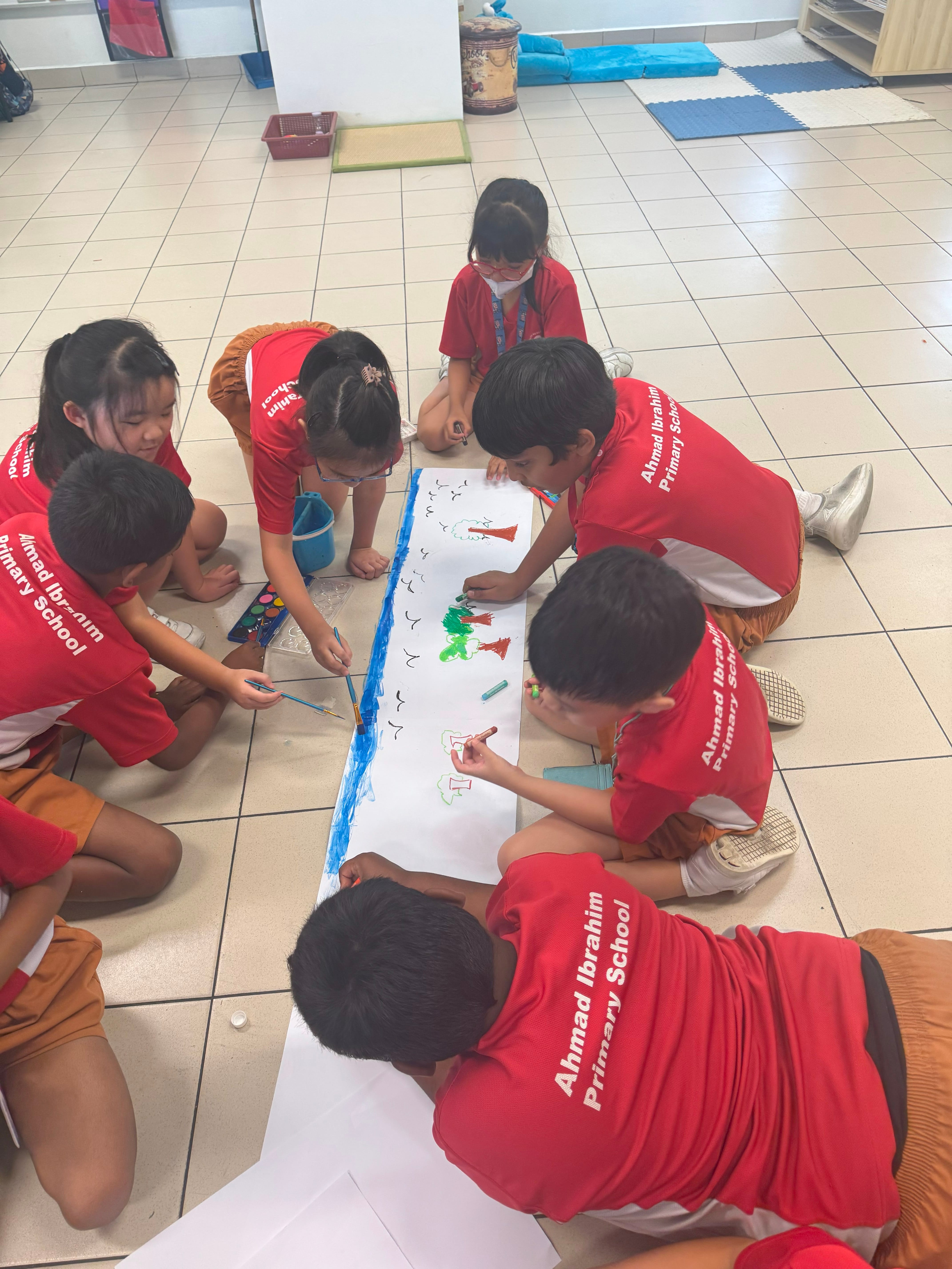 Students work together on a large collaborative painting during a visual arts lesson.