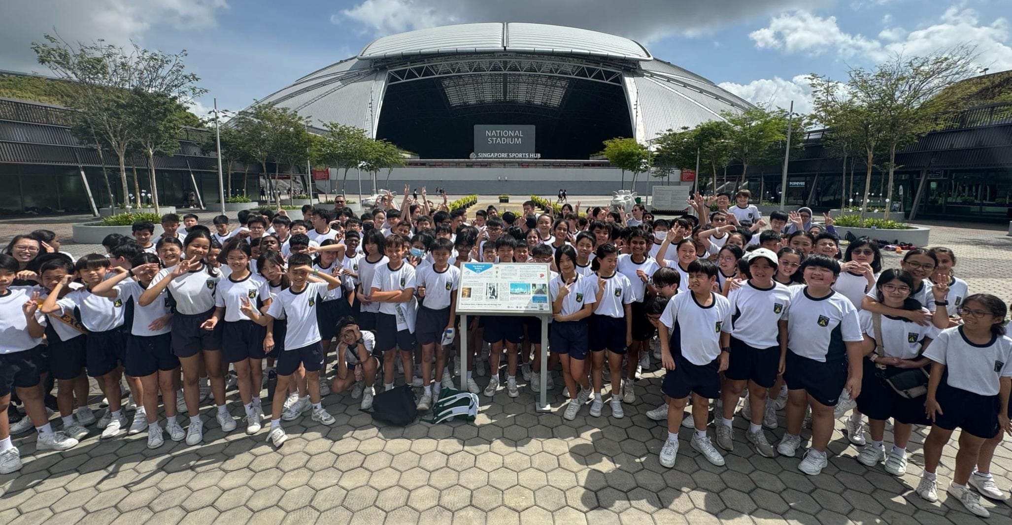 Students pose for a group photo in front of the Singapore National Stadium during a learning journey.