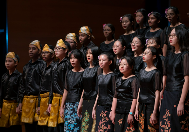 BVSS Choir members performing together on stage in black attire with colourful batik-inspired outfits at the Lee Foundation Theatre Concert.