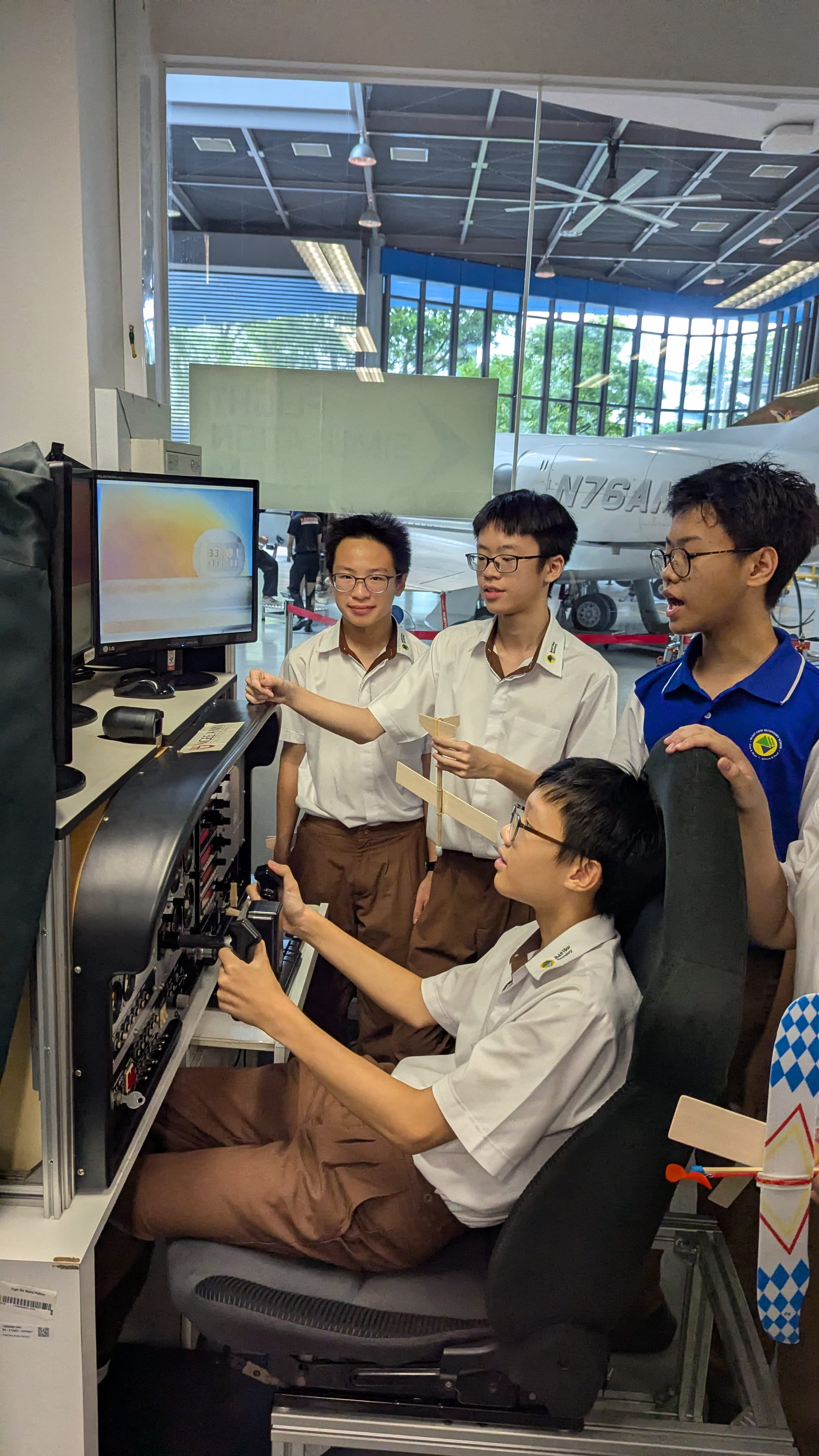 Students learning to operate an aircraft using a flight simulator during an aerospace learning experience.