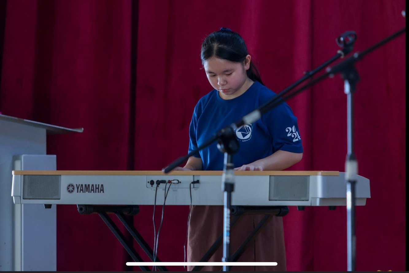 Student performing on the piano during a Youth Day performance.