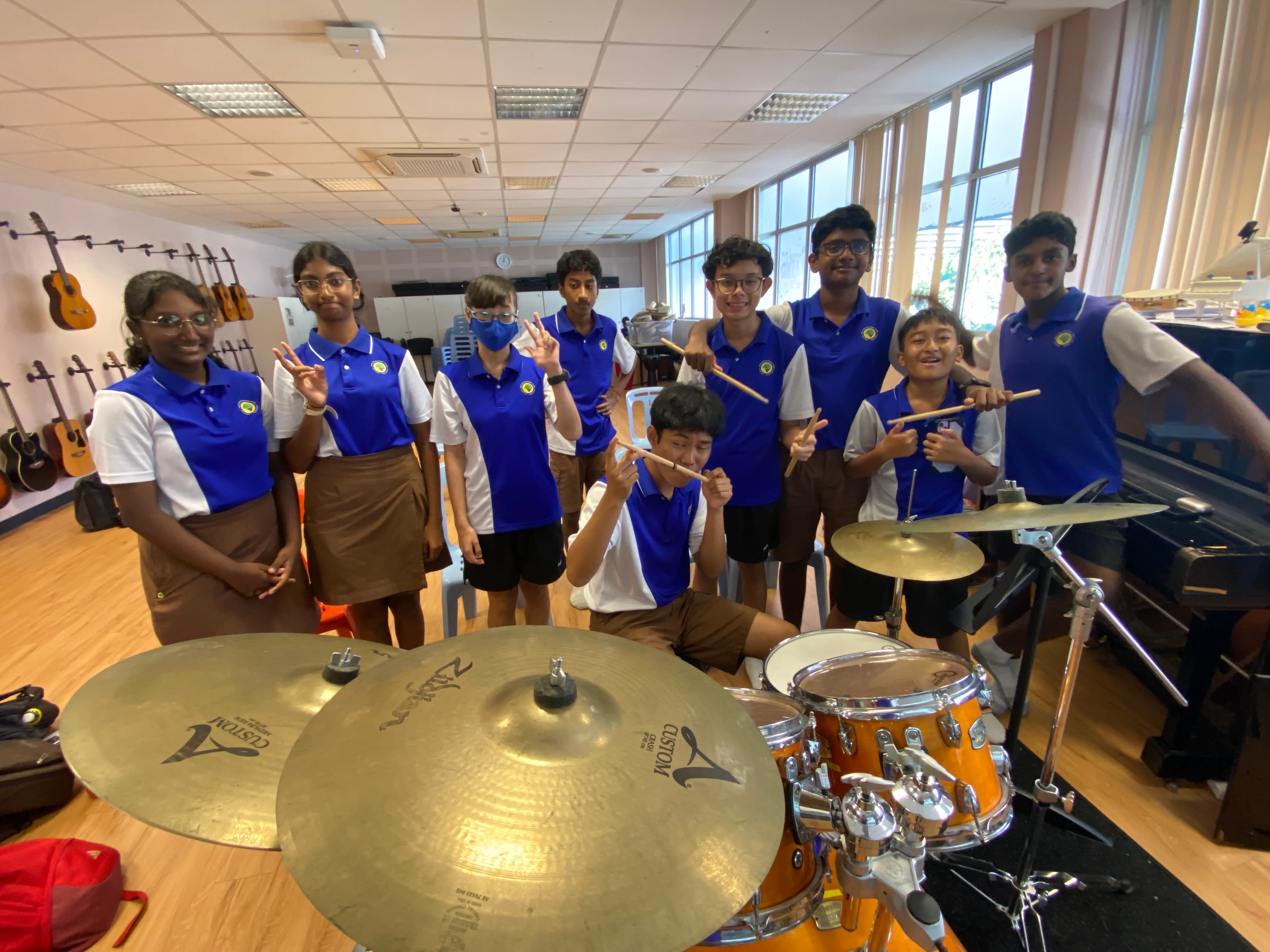 Students practising percussion instruments during a drumming enrichment session in the Music Room.