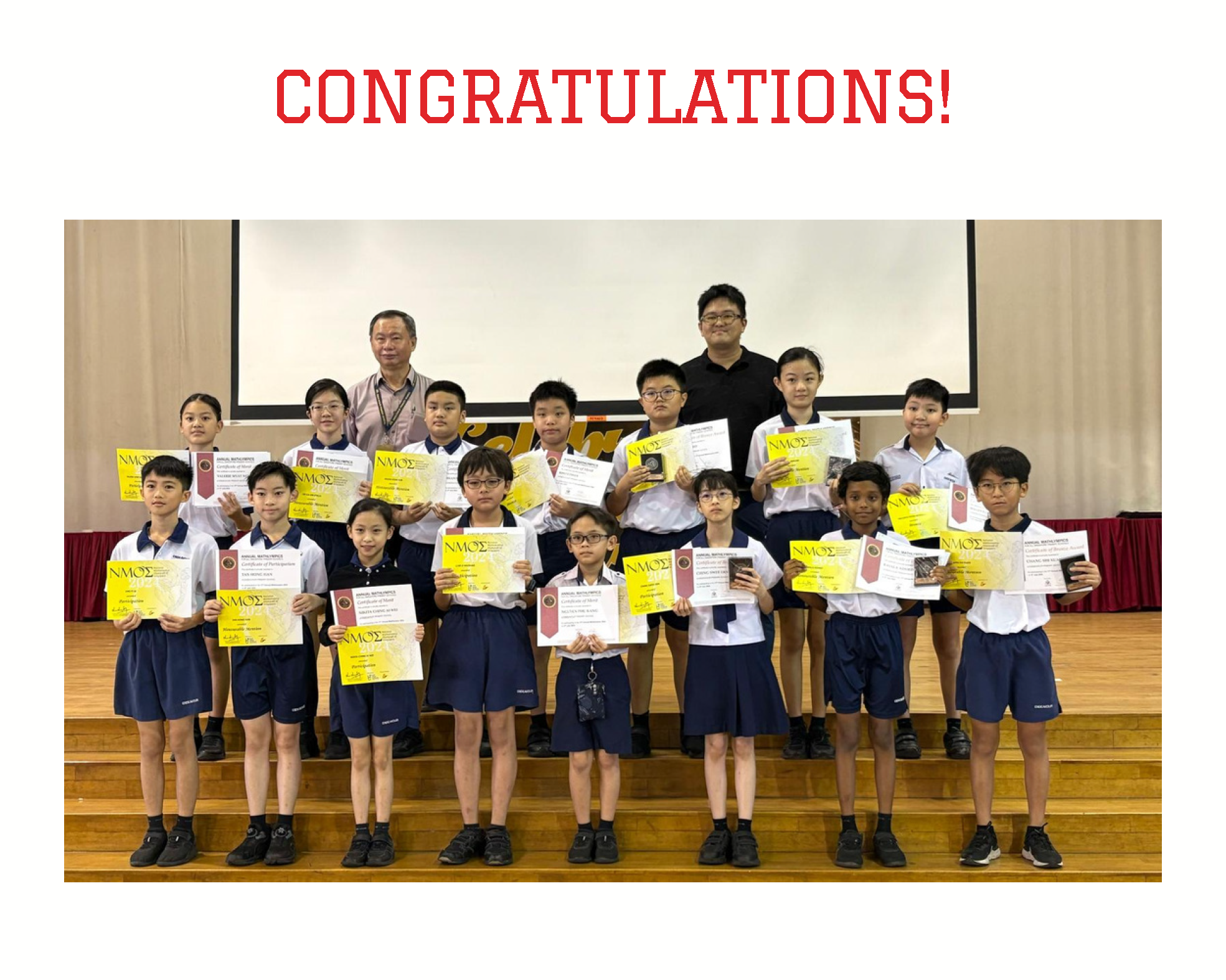 Group of school children and two adults on a stage holding NMOS certificates, under a "CONGRATULATIONS!" heading.