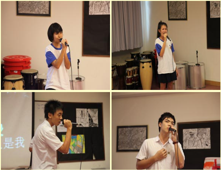 Four students in school uniforms take turns singing into a microphone in a room with drums and artwork on walls.