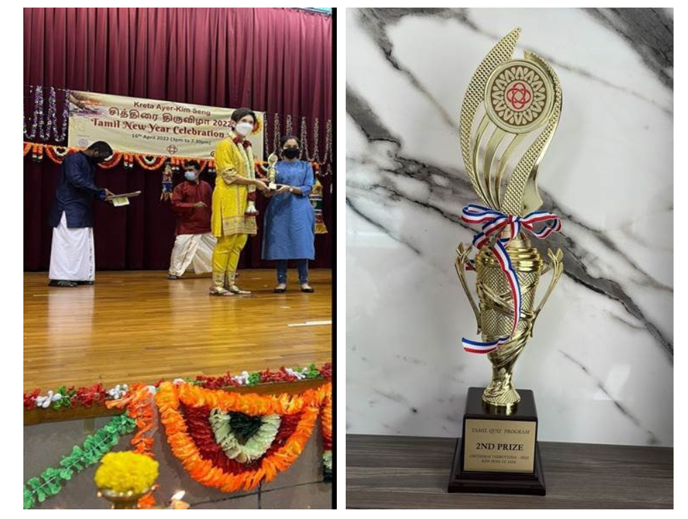 People on a decorated stage at a Tamil New Year 2022 event, beside a gold 2nd Prize trophy with a ribbon.