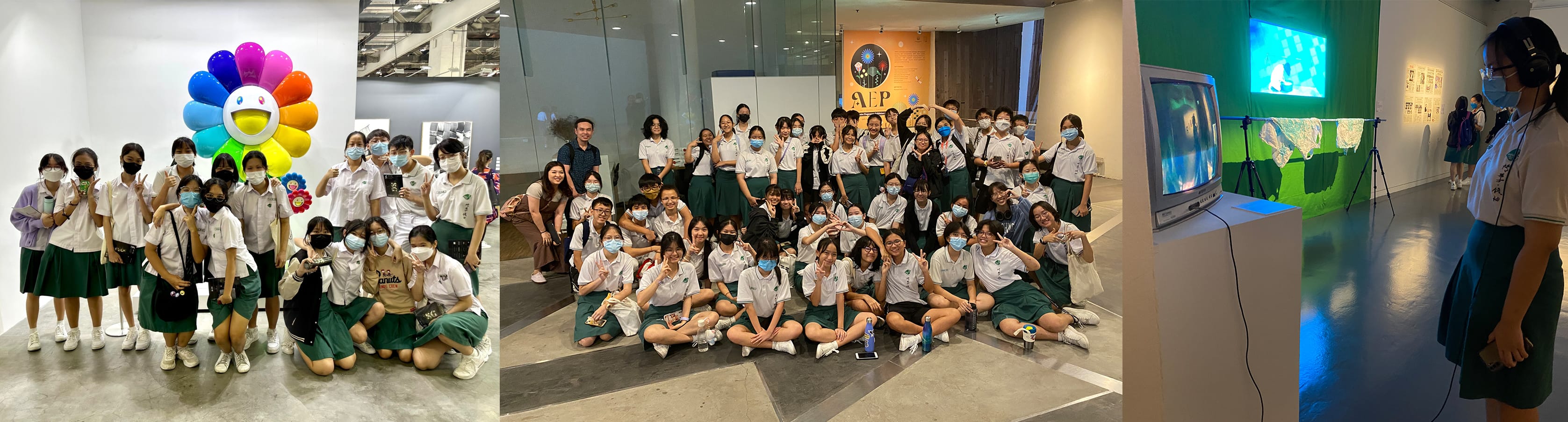 Students in white shirts and green skirts pose in groups at an art gallery, with a colorful flower sculpture nearby.